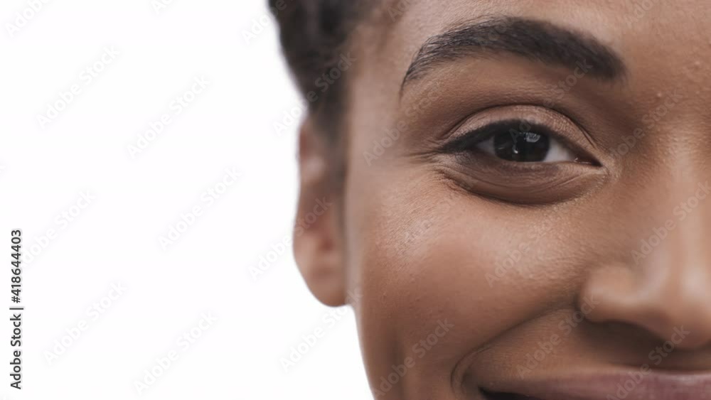 Half face portrait of pretty african american lady smiling to camera, white studio background, free space Half face portrait of pretty african american lady smiling to camera, white studio background, free space