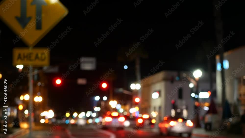 Defocused evening street, blurred bokeh. Lights of city and cars on rainy night. Reflection of electric lamps. Automobiles on road in soft focus. Twilight illuminated town, Oceanside, California USA. Defocused evening street, blurred bokeh. Lights of city and cars on rainy night. Reflection of electric lamps. Automobiles on road in soft focus. Twilight illuminated town, Oceanside, California USA.