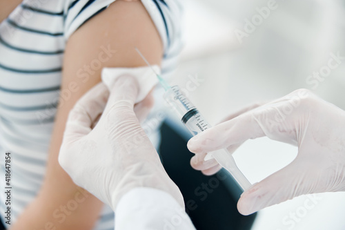 male doctor injections into patient's arm close-up covid vaccination