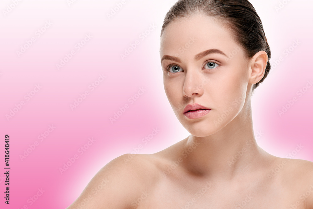 Portrait of attractive smiling girl with clean fresh face on a pink background with a shaded white outline Portrait of attractive smiling girl with clean fresh face on a pink background with a shaded white outline