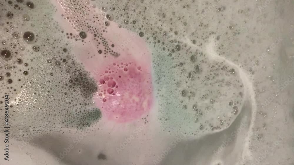The bath fills with water and colorful foam. Video. Bubbles. Preparation for taking a bath. Close-up. No people The bath fills with water and colorful foam. Video. Bubbles. Preparation for taking a bath. Close-up. No people