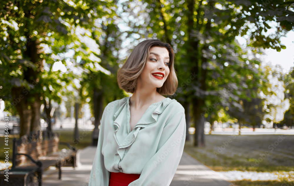 romantic woman in shirt skirt walking in the park in summer near green trees romantic woman in shirt skirt walking in the park in summer near green trees