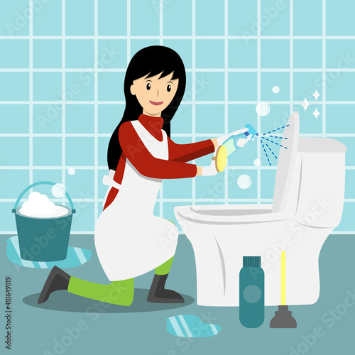 Young woman cleaning the bathroom spraying  liquid toilet cleaner on toiet lid