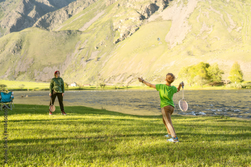Obraz premium child and woman playing in badminton outdoors