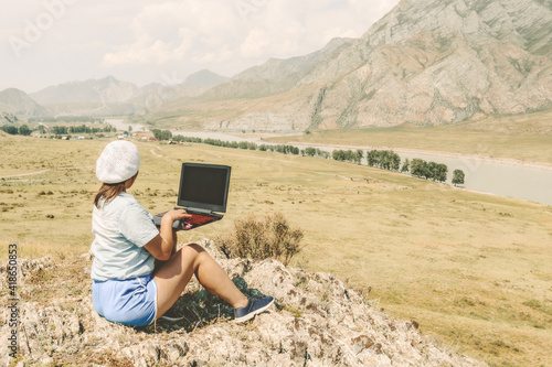 woman with laptop in the mountains