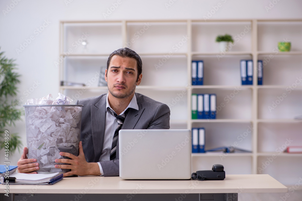 Young businessman rejecting new ideas with lots of papers Young businessman rejecting new ideas with lots of papers