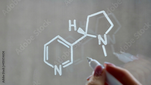 Drawing of the chemical structure of nicotine on the glass with a white marker.