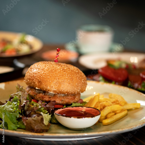 Fresh burger with grilled meat and French fries. Fast food menu concept. closev up shot. Nutritious snack or lunch. Classic American food. Square format for posting on social media.