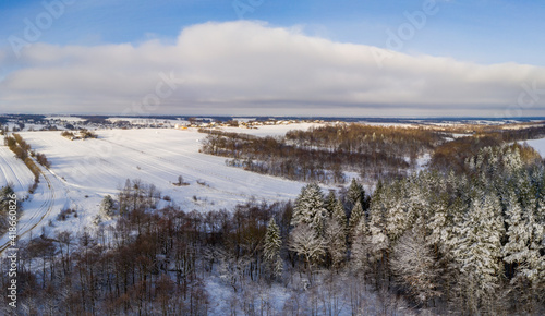 Winter landscape of forest and fields, snowy fields and trees in the forest.