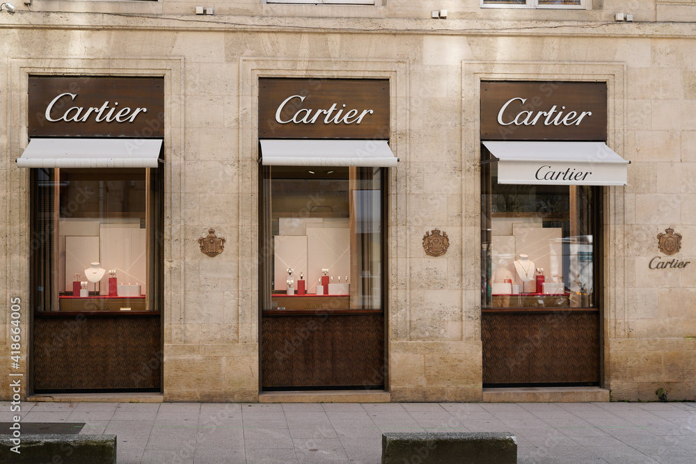 Cartier logo sign and brand text front of facade boutique fine jewelry watches bridal sets shop accessories and fragrances store Adobe Stock