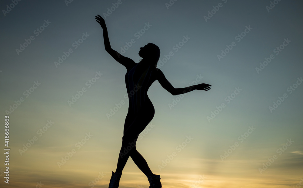 female silhouette on sunset sky background of dancing woman, silhouette