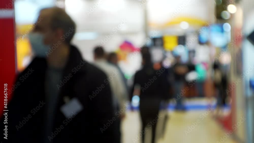 many people inside a large hall inside a modern business center.