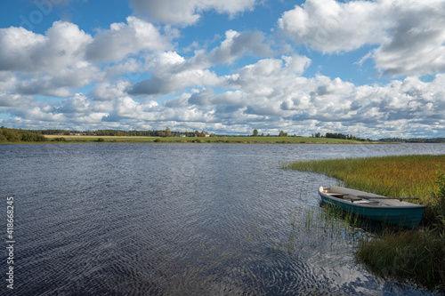 Boat on a river with agriculture fields and clouds
