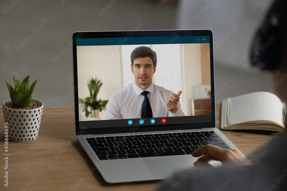 Close up back view of woman sit at desk at home office have webcam online virtual conference with boss or CEO. Female employee talk speak on video call on computer with client. Technology concept. Close up back view of woman sit at desk at home office have webcam online virtual conference with boss or CEO. Female employee talk speak on video call on computer with client. Technology concept.