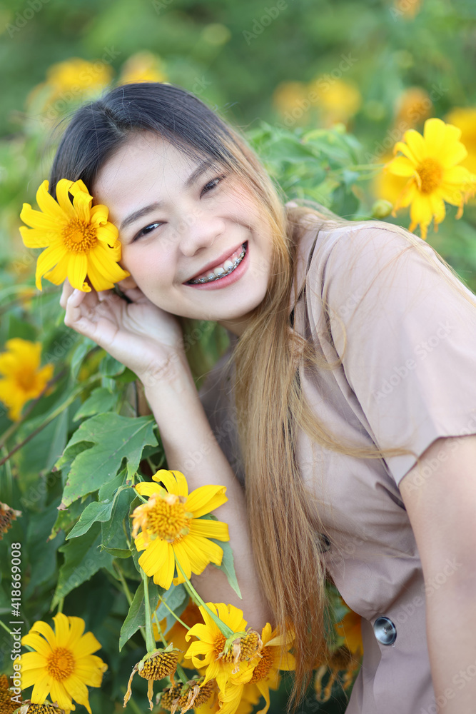 Portrait of asian women smiling with yellow flowers in the garden. Beautiful asian girl travel in the summer. Portrait of asian women smiling with yellow flowers in the garden. Beautiful asian girl travel in the summer.