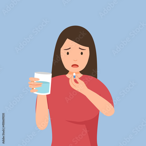 Woman taking medicine for illness treatment. Female take vitamin or supplement capsule pill with water.
