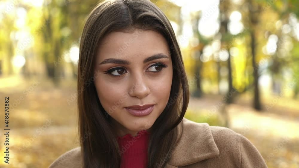 Close, happy look at camera of beautiful, brown-eyed girl in autumn, sunny park Close, happy look at camera of beautiful, brown-eyed girl in autumn, sunny park