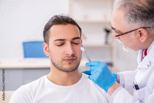 Young man visiting experienced doctor dermatologist