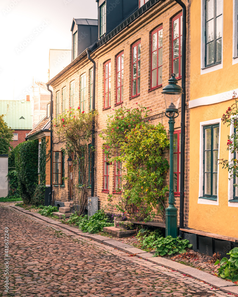 Historical town houses on a narrow cobblestoned street in medieval parts of city Lund Sweden