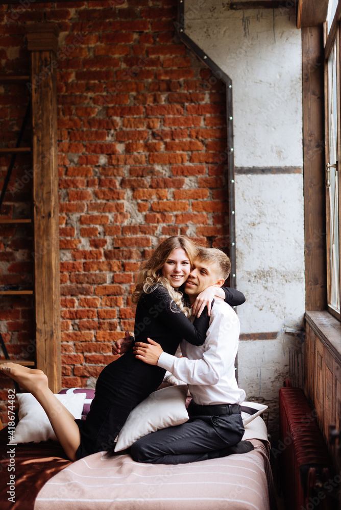 Obraz premium A young man and a woman embrace in a loft-style interior