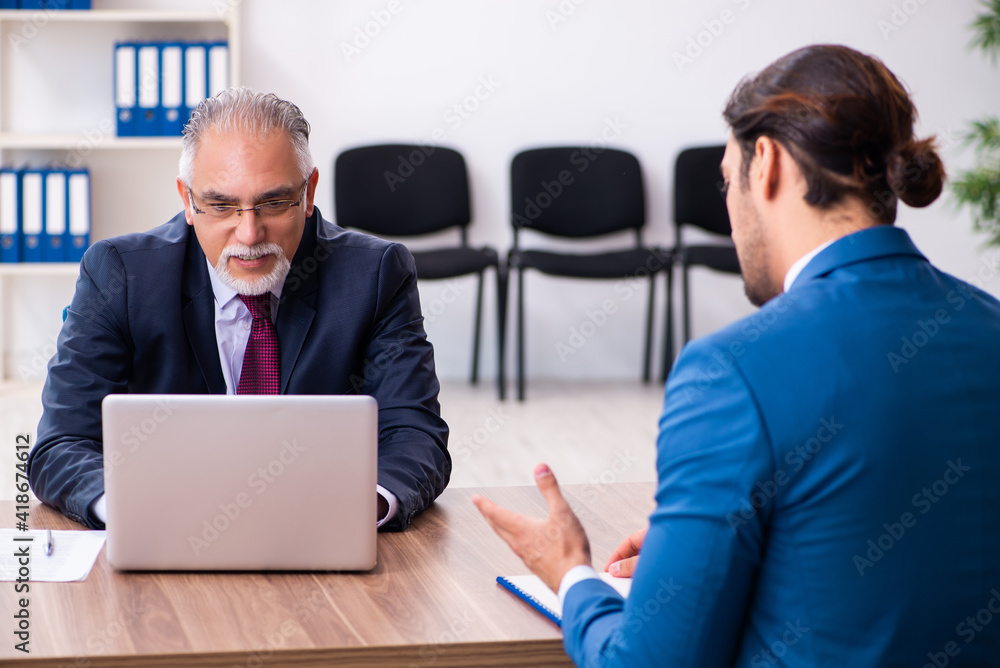 Fototapeta premium Young male candidate employee meeting with old recruiter