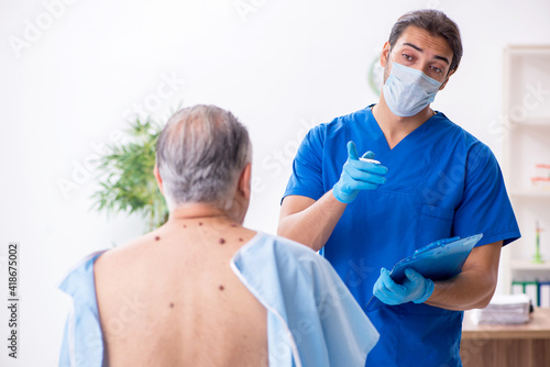 Old man visiting young male doctor dermatologist © Elnur