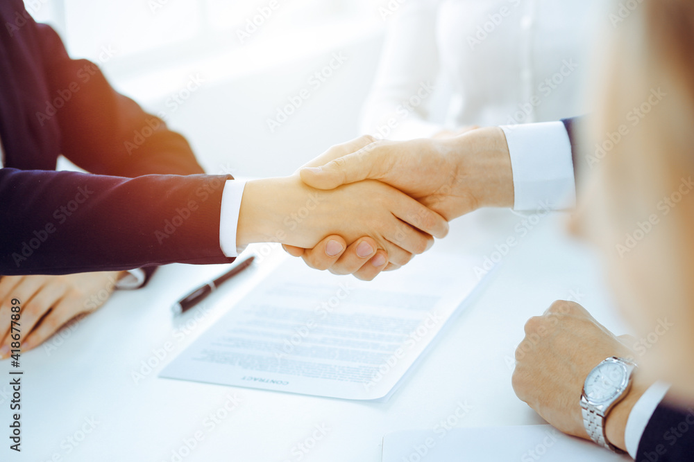 Businesspeople or lawyers shaking hands finishing up meeting or negotiation in sunny office. Business handshake and partnership Businesspeople or lawyers shaking hands finishing up meeting or negotiation in sunny office. Business handshake and partnership