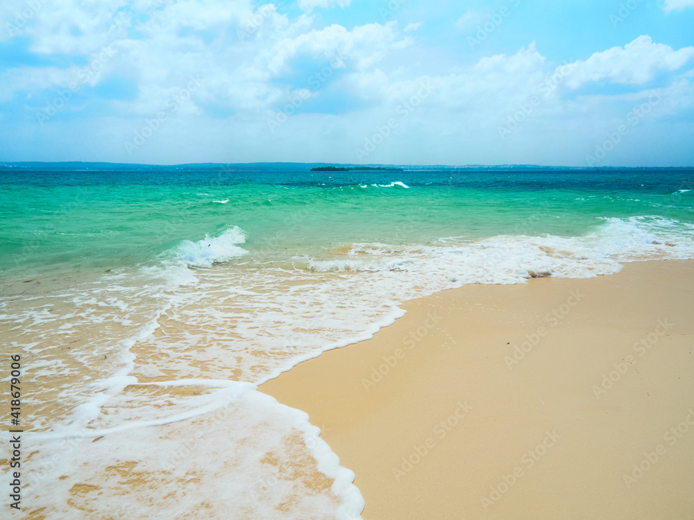 Scenic view to the turquoise ocean wave from sand beach and blue sky with clouds. Zanzibar, Tanzania. Scenic view to the turquoise ocean wave from sand beach and blue sky with clouds. Zanzibar, Tanzania.