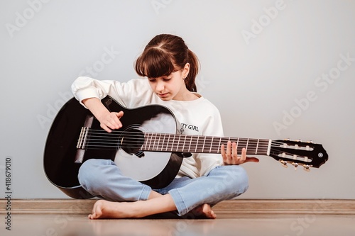 Niña tomando clases de guitarra online por la tablet