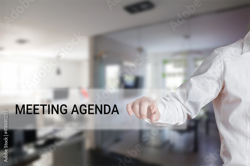 Male hand pressing the word meeting agenda on a virtual search display bar. Business meeting program schedule