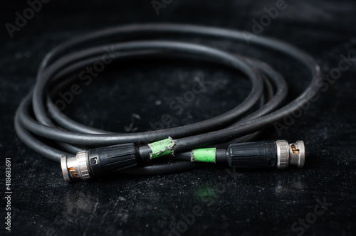 Black cable for transmission of video signal in filmmaking on a dark background