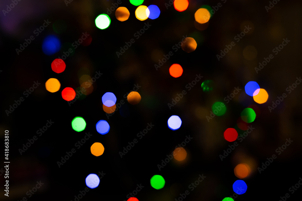 Colorful lights of festive garland blurred on a dark background