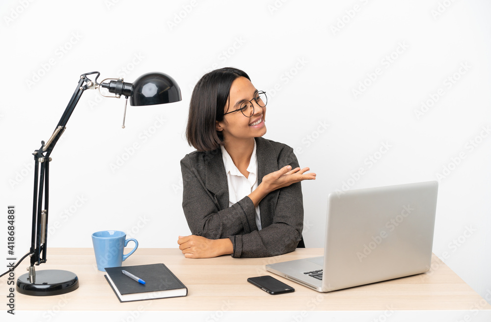 Young business mixed race woman working at office presenting an idea while looking smiling towards Young business mixed race woman working at office presenting an idea while looking smiling towards