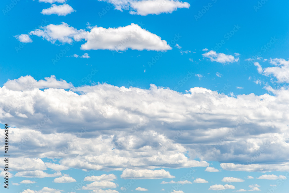Fototapeta premium White cumulus clouds against a deep blue sky
