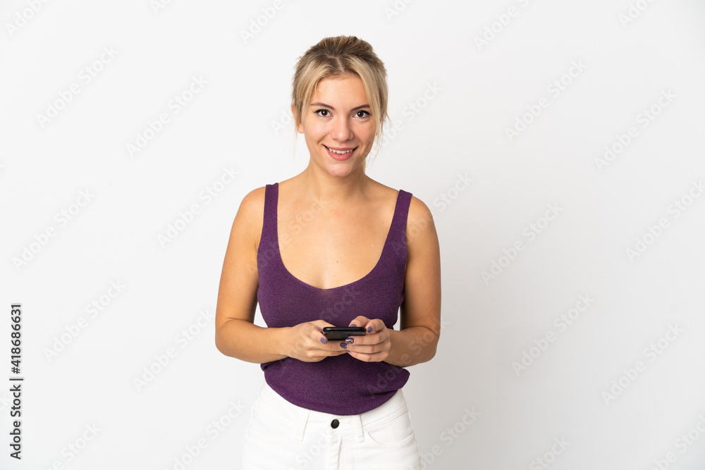 Young Russian woman isolated on white background sending a message with the mobile Young Russian woman isolated on white background sending a message with the mobile
