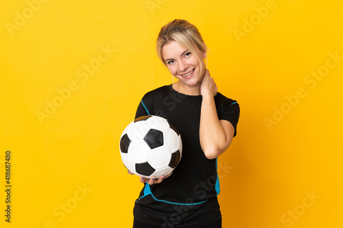 Young Russian football player woman isolated on yellow background laughing © luismolinero