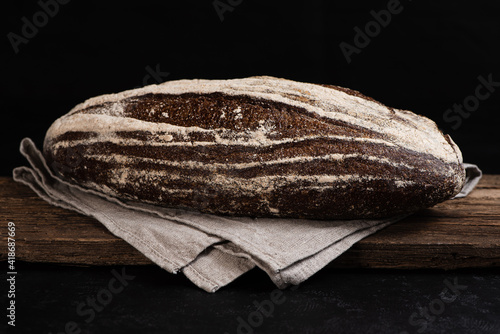 Obraz na płótnie Freshly baked homemade artisan sourdough rye bread on wooden board. Closeup of farmhouse bread at leaven. Low key. w salonie