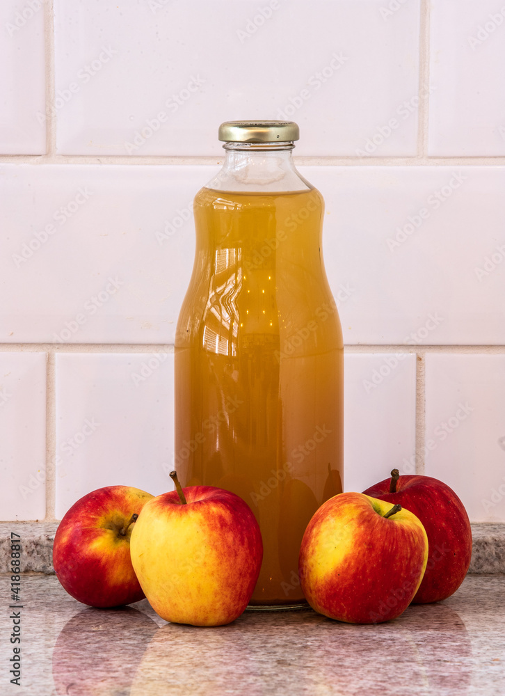Natural juice from organic apples in bottle and apples on the side Natural juice from organic apples in bottle and apples on the side