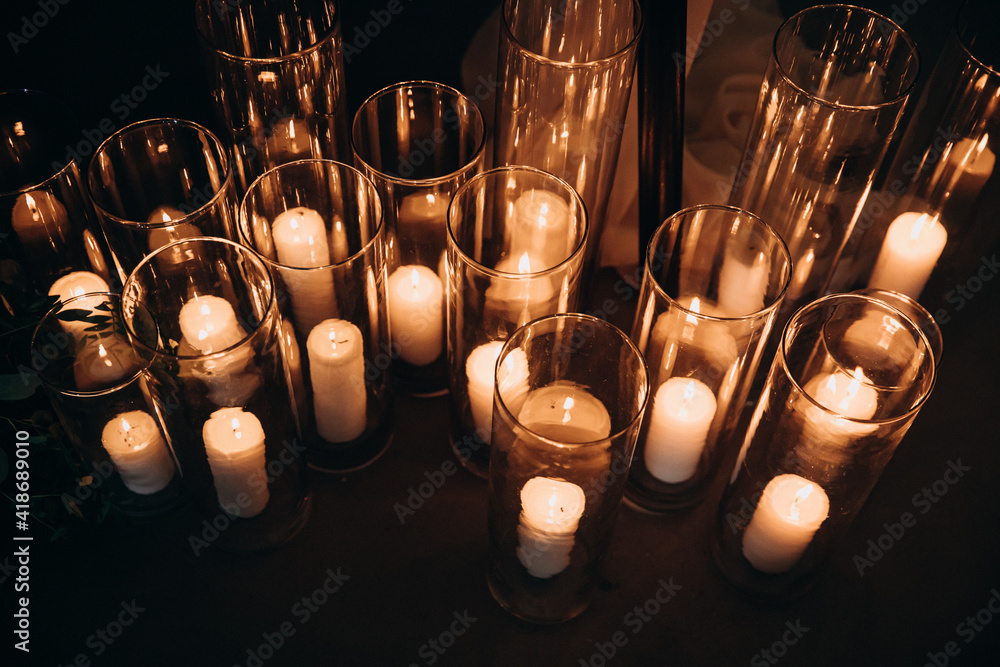 Wedding decorations. Candles are burning in glass vases, evening decor