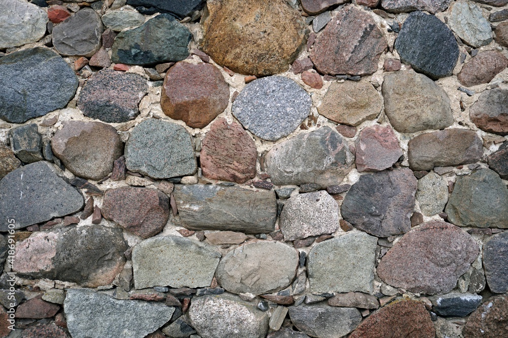The wall of the building is made of chipped stone on a mortar. Beautiful texture The wall of the building is made of chipped stone on a mortar. Beautiful texture