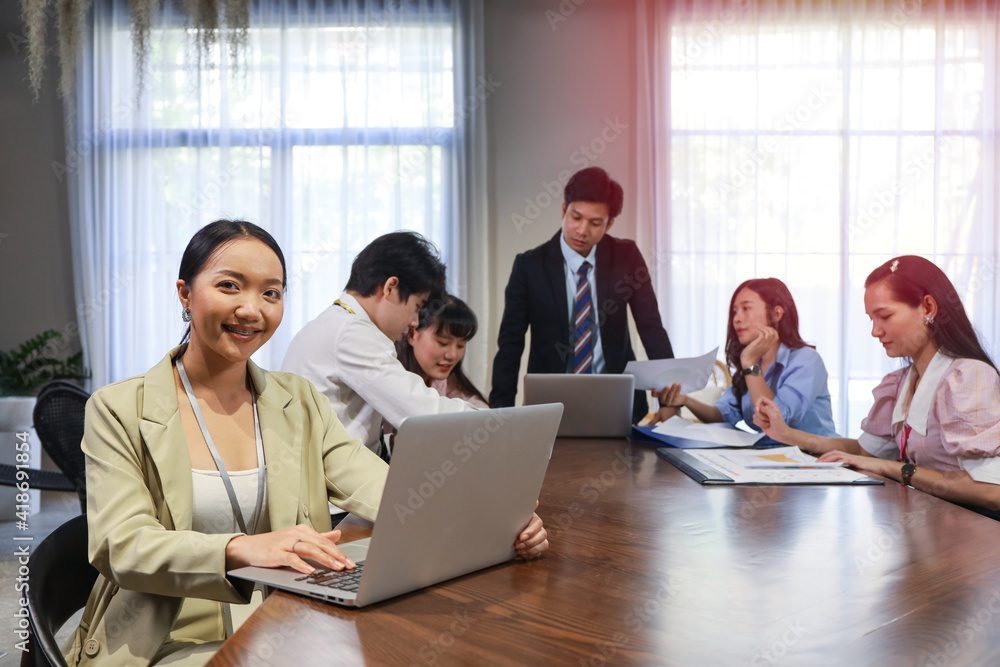 Portrait of Young business woman while talking and discussing with coworker team while group meeting in conference room Portrait of Young business woman while talking and discussing with coworker team while group meeting in conference room