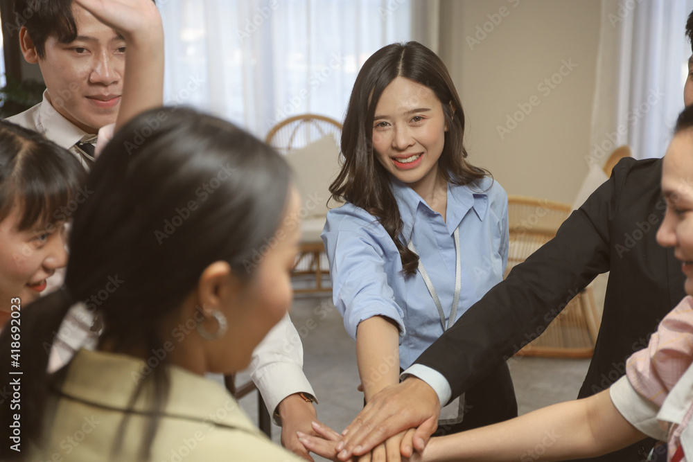 Young business people stack hands with coworker team while group teamwork meeting in conference room Young business people stack hands with coworker team while group teamwork meeting in conference room