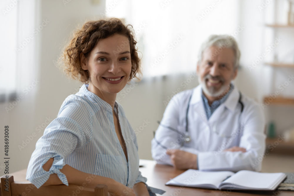 Portrait of happy young female patient sit in private hospital satisfied with good medical service. Smiling woman client look at camera feel excited after consultation in clinic. Healthcare concept. Portrait of happy young female patient sit in private hospital satisfied with good medical service. Smiling woman client look at camera feel excited after consultation in clinic. Healthcare concept.
