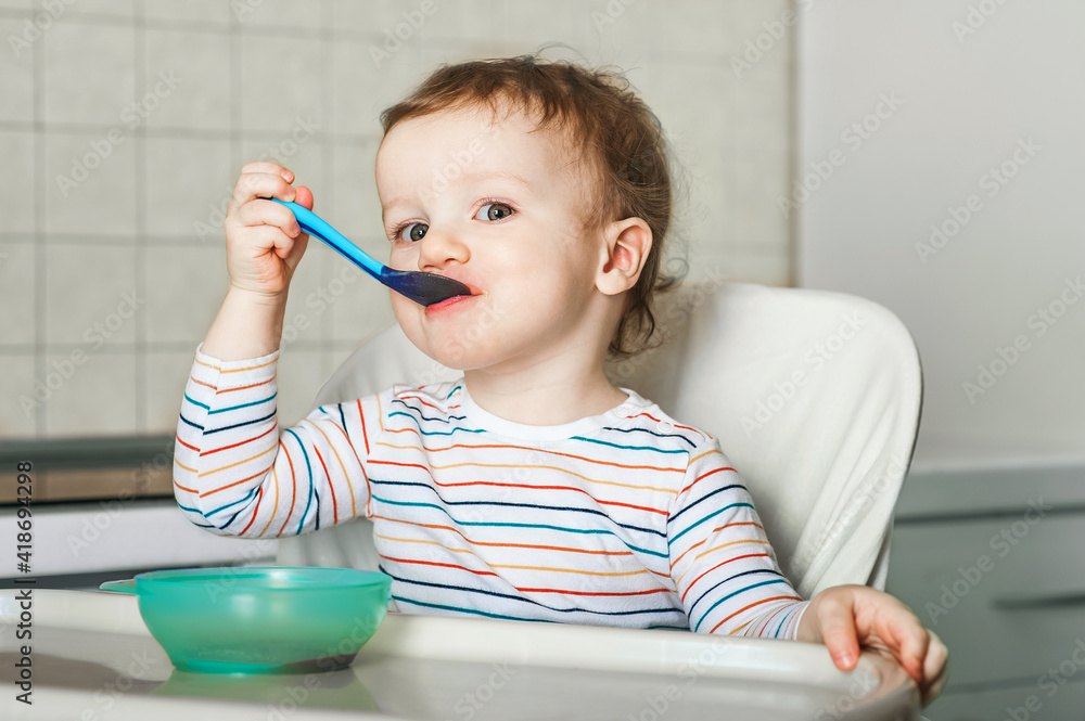 The Child Eats And Holds Spoon With Fruit Vegetables Puree Healthy the-child-eats-and-holds-spoon-with-fruit-vegetables-puree-healthy