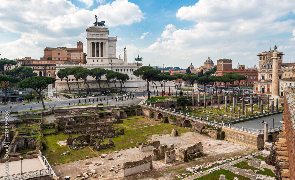 View of roman forum ruins in front of historical palace built by Mussolini in Rome