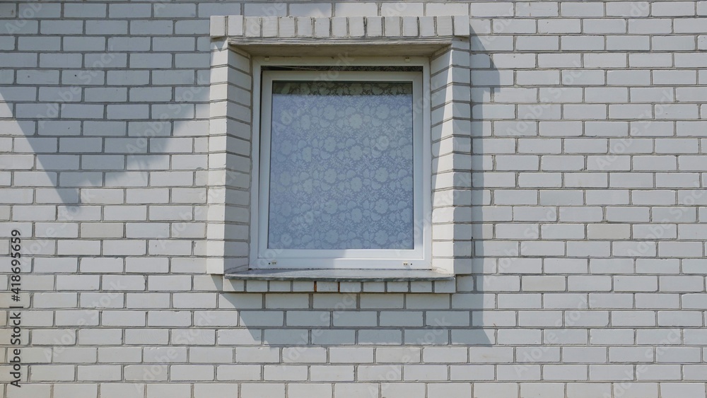 Fototapeta premium A lonely window in a white brick house.
