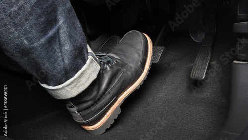 Accelerator and breaking pedal in a car. Close up the foot pressing foot pedal of a car to drive ahead. Driver driving the car by pushing accelerator pedals of the car. inside vehicle. 
 photo