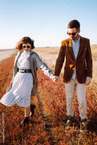 Young couple walks in the park during the spring and hugs. Enjoying time together. The concept of youth, love and lifestyle.