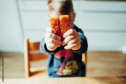 Kochen mit Kindern, Kleiner Junge kocht mit seinen Eltern und zeigt Zutaten in die Kamera