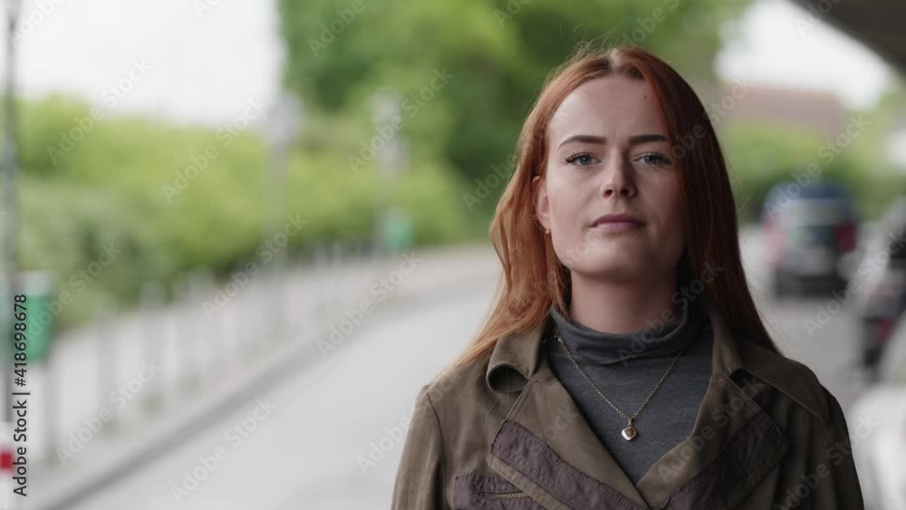 [4k] a young beautiful strong and hopeful ginger woman raising her head looking into the camera